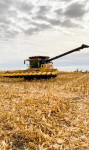 The combine comes to rest at the end of a mile long row of harvested corn.