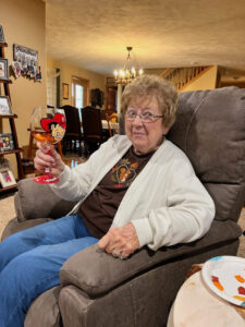 Grandma enjoys a glass of wine with the family.