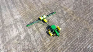 An aerial drone view captures our tractor and planter finishing a pass through the field.