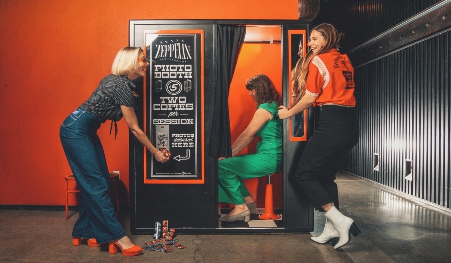 Three women have fun at a photo booth