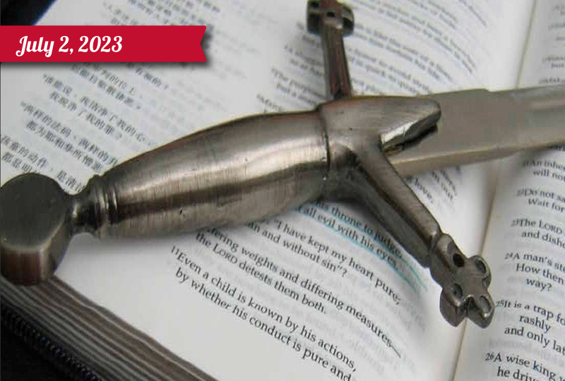 A sword handle rests on an open bible
